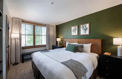 a bedroom with a large bed and a green wall at Zephyr Mountain Lodge - Premium Rated Condo 1217 in Winter Park