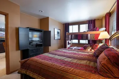a bedroom with a bed and a flat screen tv at Premium Ski-Slope View Two Bedroom Zephyr Mountain Lodge Condo condo in Winter Park