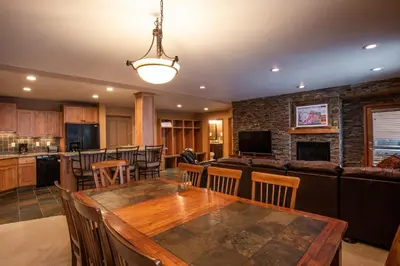 a kitchen and living room with a table and a couch at Premium Ski-Slope View Two Bedroom Zephyr Mountain Lodge Condo condo in Winter Park