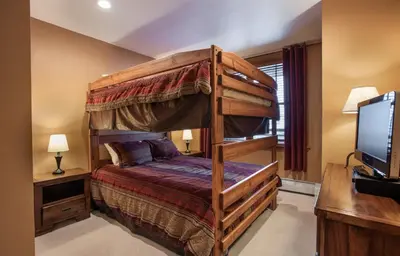 a bedroom with a bunk bed and a television at Premium Ski-Slope View Two Bedroom Zephyr Mountain Lodge Condo condo in Winter Park