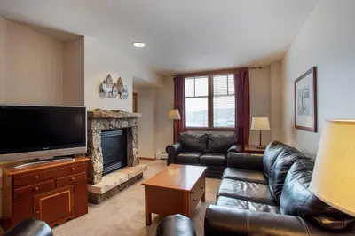 a living room with leather furniture and a flat screen tv at Roomy Zephyr Mountain Lodge Condo with Perfect Slope View from Balcony condo in Winter Park
