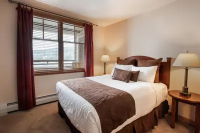 a bedroom with a large bed and a window at Roomy Zephyr Mountain Lodge Condo with Perfect Slope View from Balcony condo in Winter Park