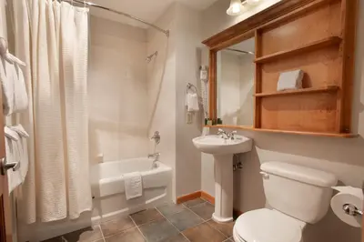 a bathroom with a toilet and a sink and a tub at Comfortable Mountain Adventure Condo at Zephyr Mountain Lodge with Village View condo in Winter Park