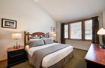 a bedroom with a bed and a desk and a window at Comfortable Mountain Adventure Condo at Zephyr Mountain Lodge with Village View condo in Winter Park