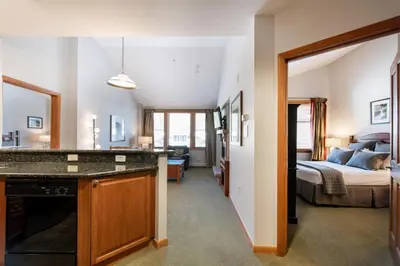 a living room with a bedroom and a bed at Comfortable Mountain Adventure Condo at Zephyr Mountain Lodge with Village View condo in Winter Park