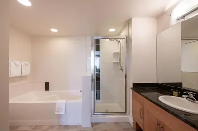 a bathroom with a shower and a tub and a sink at Comfortable Fraser Crossing Founders Pointe Condo with Easy Access to the Gondola condo in Winter Park