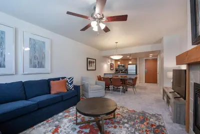 a living room with a blue couch and a table at Comfortable Fraser Crossing Founders Pointe Condo with Easy Access to the Gondola condo in Winter Park