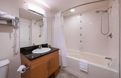 a bathroom with a sink and a tub and a toilet at Comfortable Fraser Crossing Founders Pointe Condo with Easy Access to the Gondola condo in Winter Park