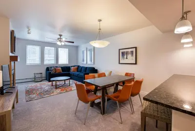 a living room with a table and chairs and a couch at Comfortable Fraser Crossing Founders Pointe Condo with Easy Access to the Gondola condo in Winter Park