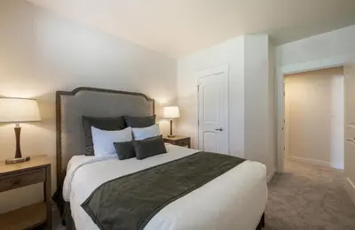 a bedroom with a large white bed with two lamps at Comfortable Fraser Crossing Founders Pointe Condo with Easy Access to the Gondola condo in Winter Park