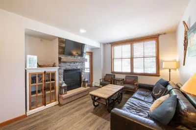 a living room with a leather couch and a fireplace at Cozy Lower Hughes View 2 BR Zephyr Mountain Lodge Condo with Ski Storage condo in Winter Park