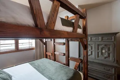 a bedroom with two bunk beds and a dresser at Cozy Lower Hughes View 2 BR Zephyr Mountain Lodge Condo with Ski Storage condo in Winter Park
