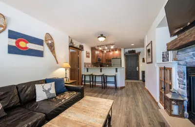 a living room with a couch and a table at Cozy Lower Hughes View 2 BR Zephyr Mountain Lodge Condo with Ski Storage condo in Winter Park
