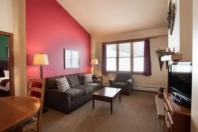 a living room with a couch and a tv at Terrific Zephyr Mountain Lodge Condo With Beautiful Views of the Slopes condo in Winter Park
