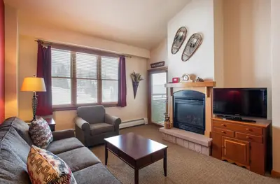 a living room with a couch and a tv at Terrific Zephyr Mountain Lodge Condo With Beautiful Views of the Slopes condo in Winter Park