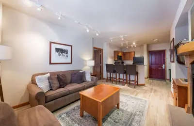 a living room with a couch and a table at Recently remodeled third floor Zephyr Mountain Lodge condo with trail view condo in Winter Park