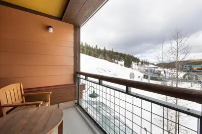 a balcony with a table and a view of a snow covered mountain at Recently remodeled third floor Zephyr Mountain Lodge condo with trail view condo in Winter Park
