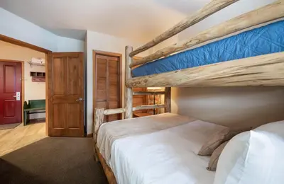 a bedroom with two bunk beds and a doorway at Recently remodeled third floor Zephyr Mountain Lodge condo with trail view condo in Winter Park