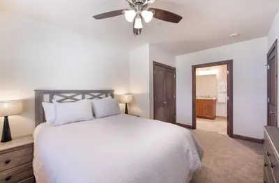 a bedroom with a white bed and a ceiling fan at Spectacular Ski-In Ski-Out Zephyr Mountain Lodge Condo with Village Corridor View condo in Winter Park
