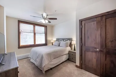 a bedroom with a bed with a ceiling fan and a window at Spectacular Ski-In Ski-Out Zephyr Mountain Lodge Condo with Village Corridor View condo in Winter Park