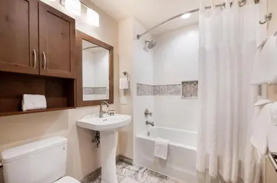 a bathroom with a sink and a toilet and a shower at Spectacular Ski-In Ski-Out Zephyr Mountain Lodge Condo with Village Corridor View condo in Winter Park