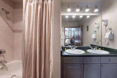 a bathroom with two sinks and a shower curtain at Lovely Mountain Adventure Zephyr Mountain Lodge Condo with Ski Storage condo in Winter Park