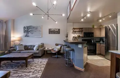 a kitchen and living room with a couch and a table at Lovely Mountain Adventure Zephyr Mountain Lodge Condo with Ski Storage condo in Winter Park