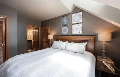 a bedroom with a large white bed and two clocks on the wall at Lovely Mountain Adventure Zephyr Mountain Lodge Condo with Ski Storage condo in Winter Park