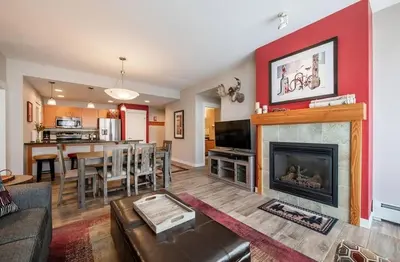 a living room with a fireplace and a dining room at Beautiful Ski-In Ski-Out Condo at Fraser Crossing Founders Pointe condo in Winter Park