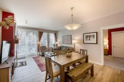 a living room with a table and a dining room at Beautiful Ski-In Ski-Out Condo at Fraser Crossing Founders Pointe condo in Winter Park