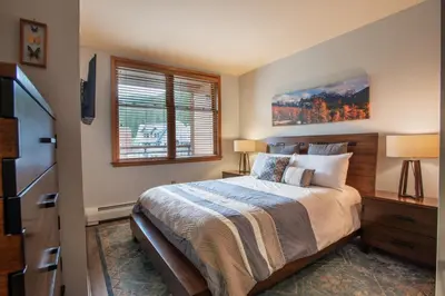 a bedroom with a bed and a tv and a window at Beautiful Zephyr Mountain Lodge Condo with wine coole! - Close to Gondola! condo in Winter Park