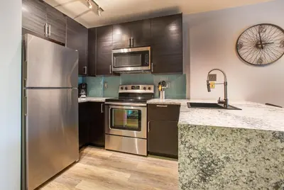 a kitchen with stainless steel appliances and wooden cabinets at Beautiful Zephyr Mountain Lodge Condo with wine coole! - Close to Gondola! condo in Winter Park