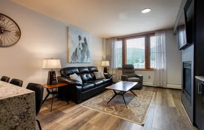a living room with a leather couch and a table at Beautiful Zephyr Mountain Lodge Condo with wine coole! - Close to Gondola! condo in Winter Park