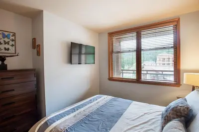 a bedroom with a bed and a window at Beautiful Zephyr Mountain Lodge Condo with wine coole! - Close to Gondola! condo in Winter Park
