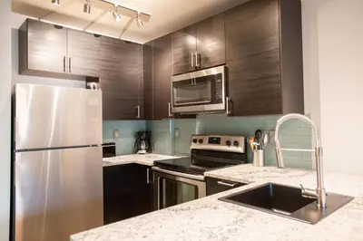 a kitchen with wooden cabinets and a stainless steel refrigerator at Beautiful Zephyr Mountain Lodge Condo with wine coole! - Close to Gondola! condo in Winter Park