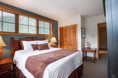 a bedroom with a large bed and windows at Unique & Comfortable Zephyr Mountain Lodge Condo with Slope and Continental Divide View condo in Winter Park