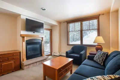 a living room with a couch and a fireplace at Zephyr Mountain Lodge Condo with views of Arapahoe National Forest condo in Winter Park
