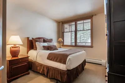 a bedroom with a large bed and a window at Zephyr Mountain Lodge Condo with views of Arapahoe National Forest condo in Winter Park