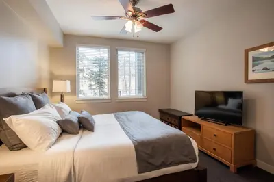 a bedroom with a bed and a flat screen tv at Beautiful Fraser Crossing Founders Pointe Condo with Upgraded Furnishings condo in Winter Park