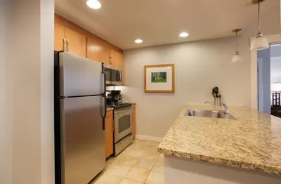 a kitchen with a stainless steel refrigerator and a sink at Beautiful Fraser Crossing Founders Pointe Condo with Upgraded Furnishings condo in Winter Park