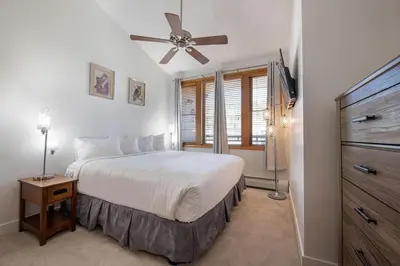 a bedroom with a bed and a ceiling fan at Comfortable Zephyr Mountain Lodge Condo with Spectacular View of the Continental Divide condo in Winter Park