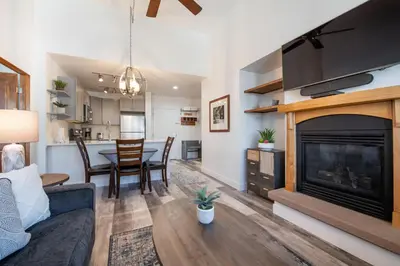 a living room with a fireplace and a table with chairs at Comfortable Zephyr Mountain Lodge Condo with Spectacular View of the Continental Divide condo in Winter Park