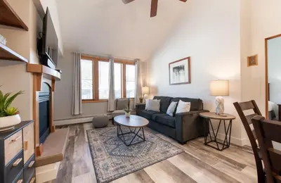 a living room with a couch and a table at Comfortable Zephyr Mountain Lodge Condo with Spectacular View of the Continental Divide condo in Winter Park