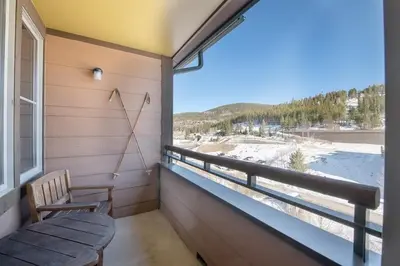 a balcony with a bench and a large window at Comfortable Zephyr Mountain Lodge Condo with Spectacular View of the Continental Divide condo in Winter Park