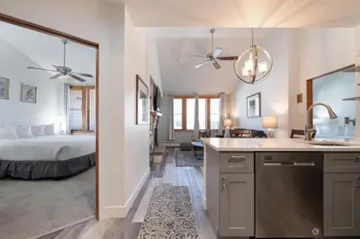 a bedroom with a bed and a kitchen with a sink at Comfortable Zephyr Mountain Lodge Condo with Spectacular View of the Continental Divide condo in Winter Park
