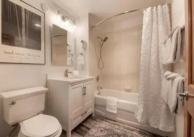 a white bathroom with a toilet and a shower at Comfortable Zephyr Mountain Lodge Condo with Spectacular View of the Continental Divide condo in Winter Park