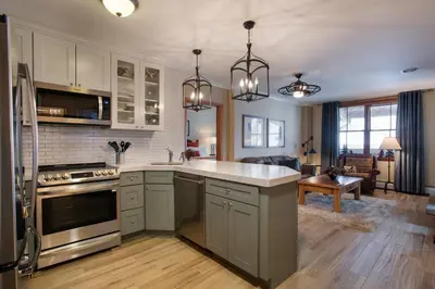 a kitchen with white counter tops and a stove top oven at Gorgeous Zephyr Mountain Lodge Condo with Corridor Ski Trail Views condo in Winter Park