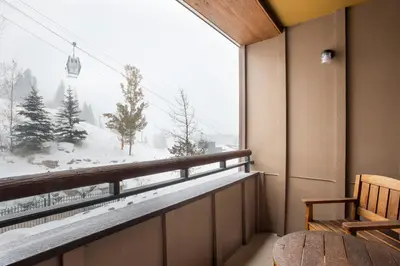 a balcony with a view of a snow covered mountain at Gorgeous Zephyr Mountain Lodge Condo with Corridor Ski Trail Views condo in Winter Park