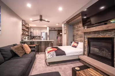 a living room with a bed and a fireplace at Striking and Unique Zephyr Mountain Lodge Condo - second floor walkout condo in Winter Park