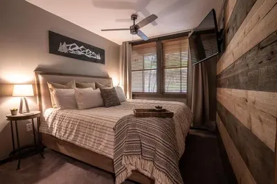 a bedroom with a large bed and a window at Striking and Unique Zephyr Mountain Lodge Condo - second floor walkout condo in Winter Park